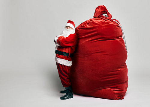 Caucasian Santa Claus with huge sack of Christmas presents
