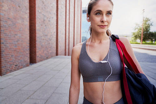 Close up of serious woman in workout clothes with headphones