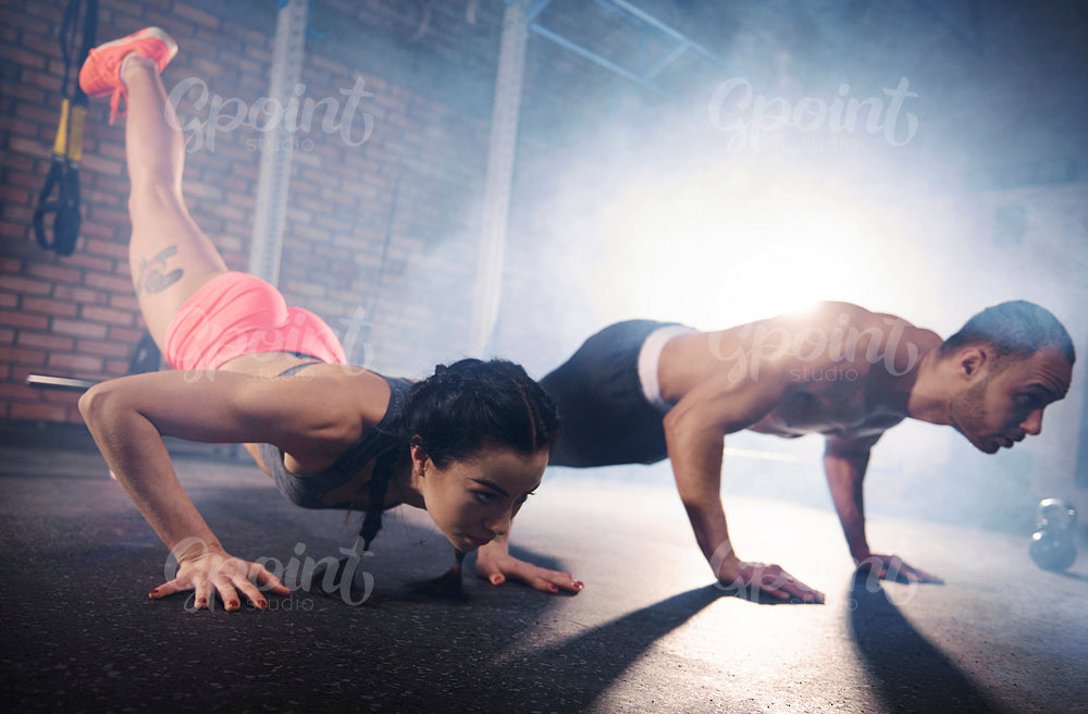 Determinated couple doing plank pose
