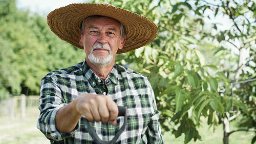 Handheld video portrait of farmer in a straw hat