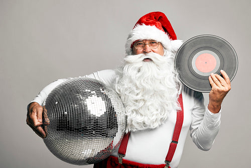 Caucasian Santa Claus celebrating with disco ball and vinyl