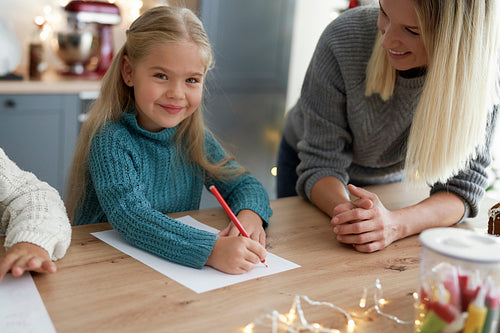 Portrait of cute girl writing letter to Santa Claus