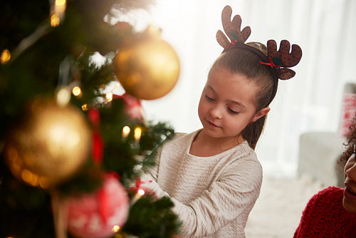 Charming girl decorating the Christmas tree