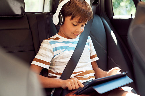 Boy sitting with a digital tablet in the car