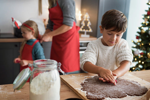 Boy making gingerbread cookies during Christmas