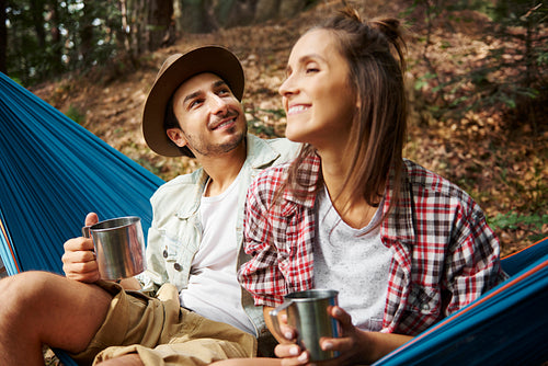 Couple relaxing in hammock in the forest