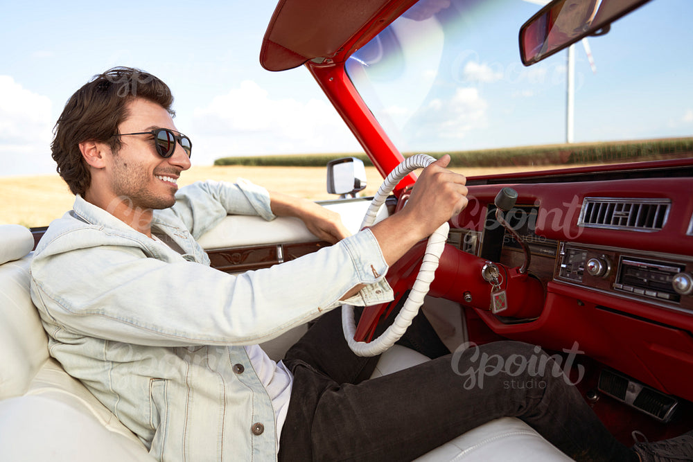 Side view of happy man driving an old car