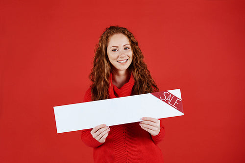 Smiling girl showing empty banner of sale