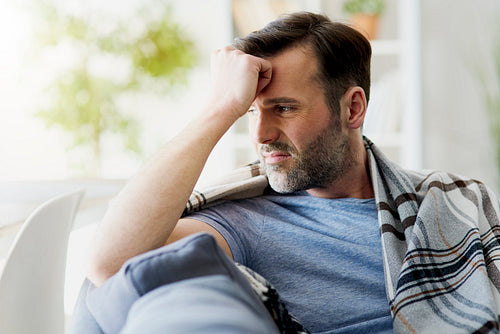 Man feeling discomfort while sitting at home