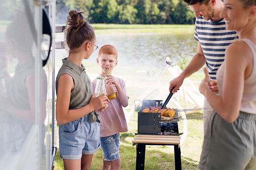 Family having barbecue during camper trip