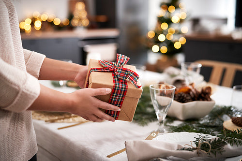 Woman holding Christmas present at home