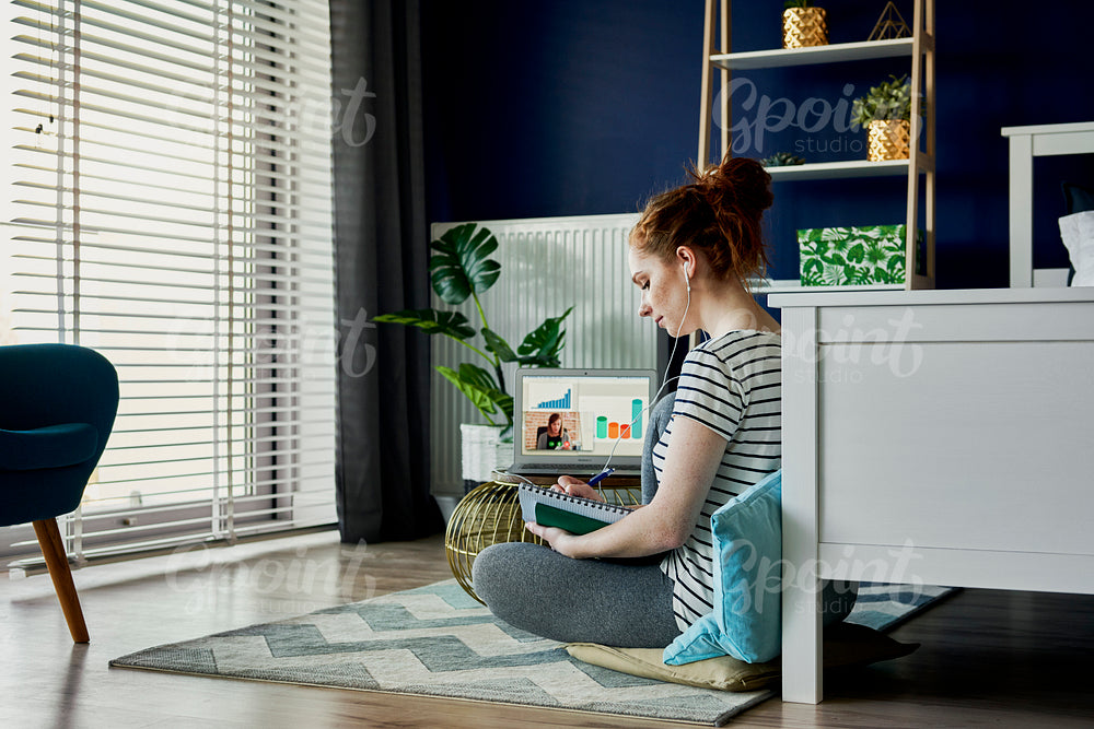 Woman sitting on floor and having a video conference