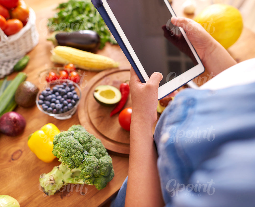 Woman with digital tablet in the kitchen