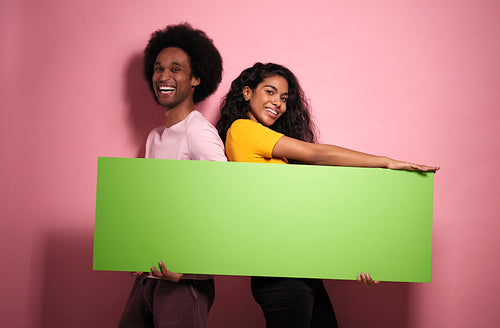 Portrait of happiness African man and woman with green banner.