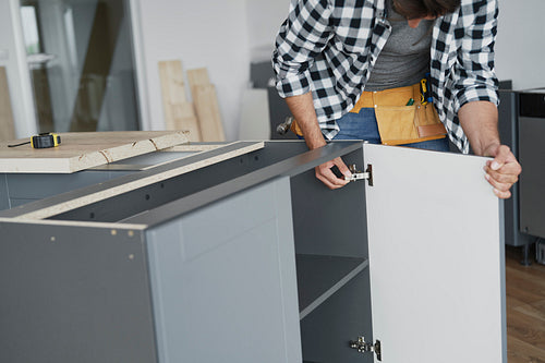 Carpenter mounting furniture hinges