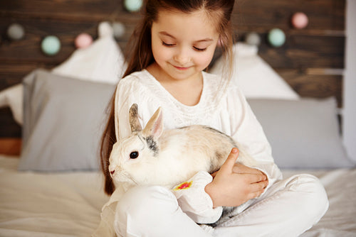 Close up of girl embracing fluffy rabbit