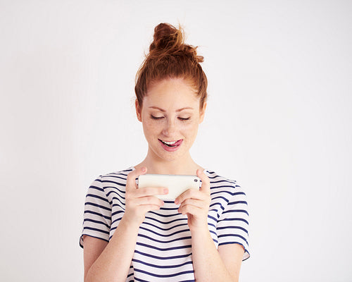 Young woman texting at studio shot