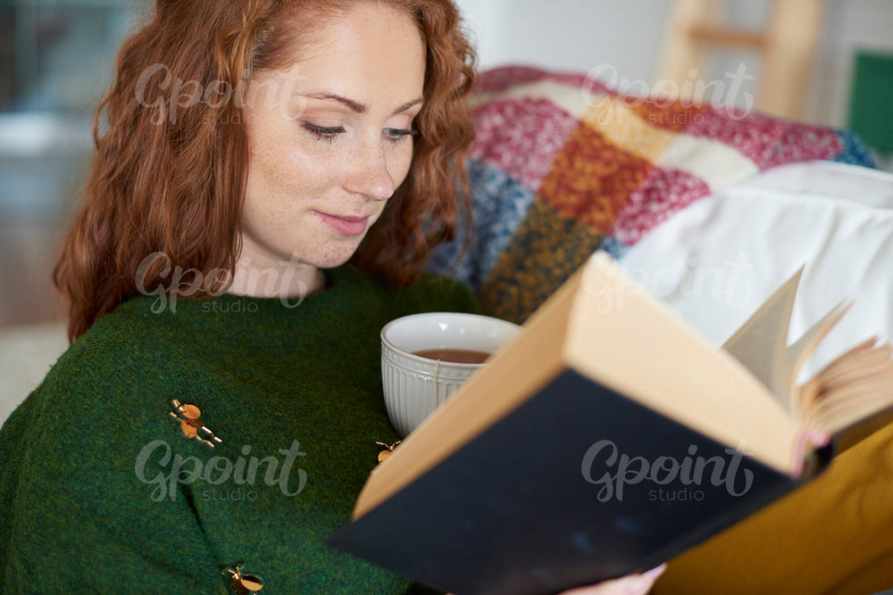Smiling woman reading book in winter day