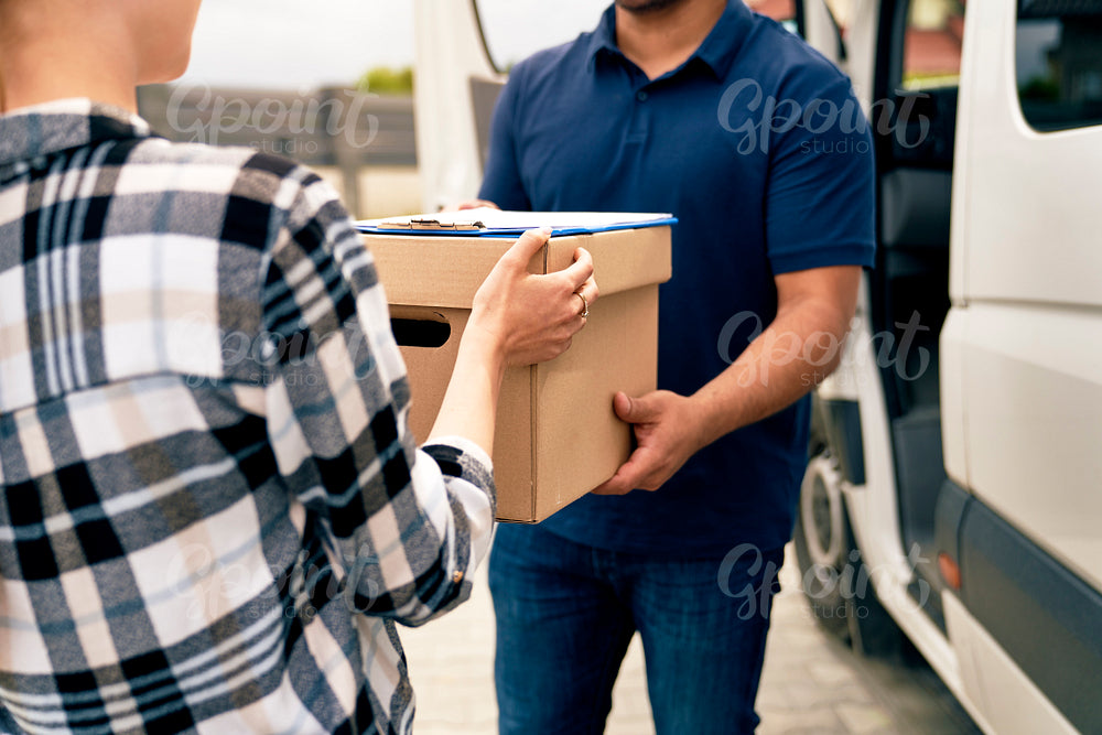 Close up of courier giving boxes to woman