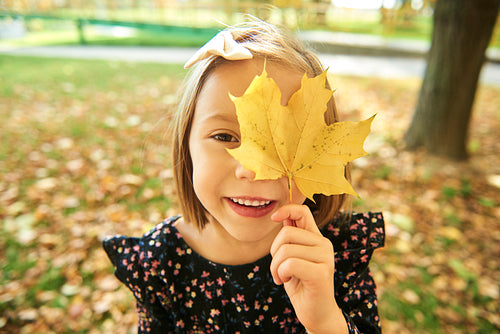 Portrait of happy girl with autumnal leafs