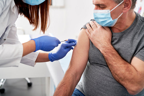 Close up of senior patient being vaccinated in a doctor's office