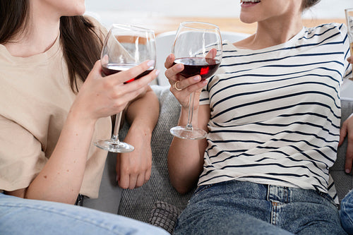 Glasses of red wine held by two women