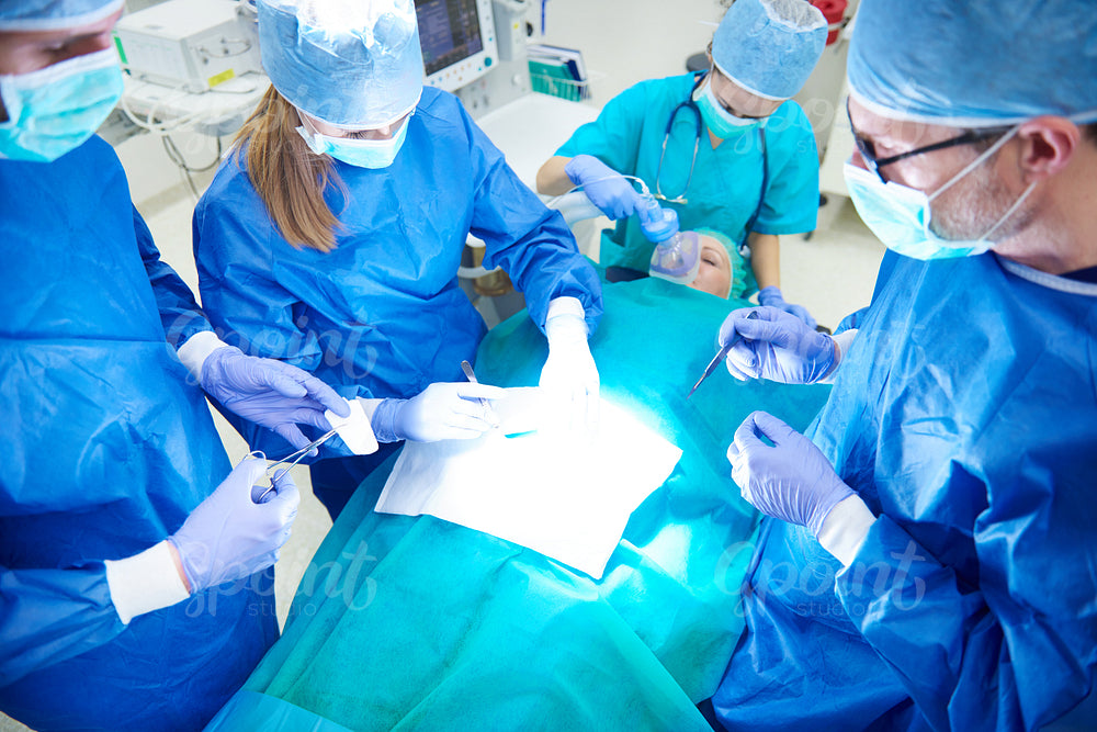 Team of busy surgeons performing an operation