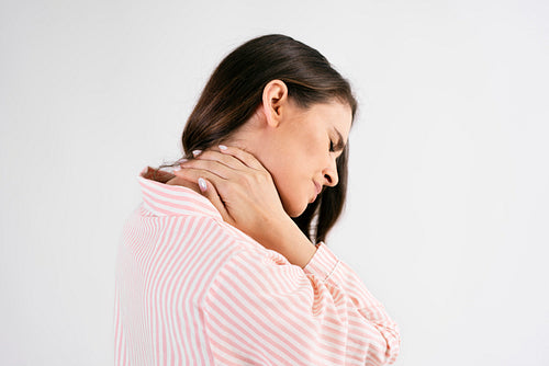 Side view of young woman suffering from neck pain
