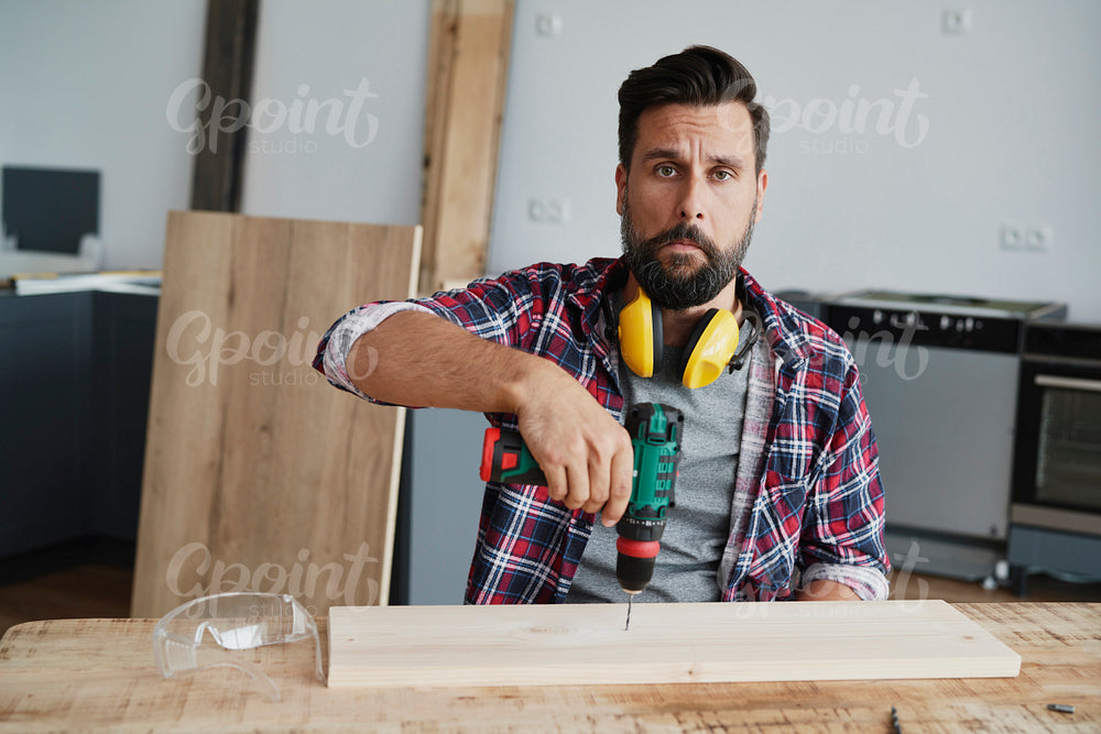 Portrait of carpenter sitting with with a funny face