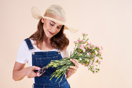 Young woman with pruning shears cutting flowers