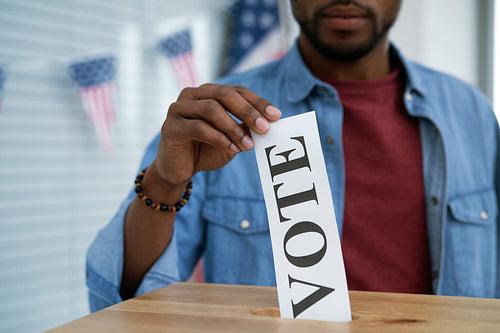 Black man giving his vote into ballot box