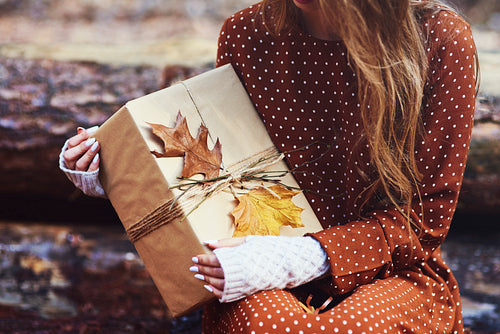 Close up of woman holding autumnal wrapped gift