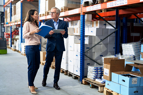 Caucasian business mature man and woman in the warehouse