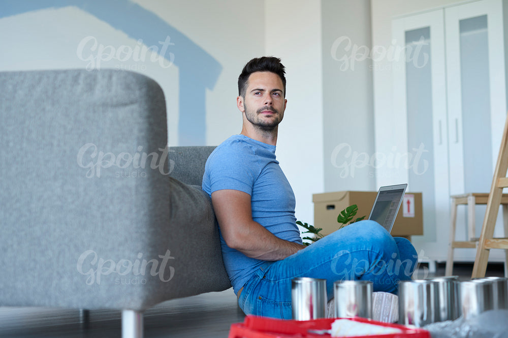 Young man with laptop in living room