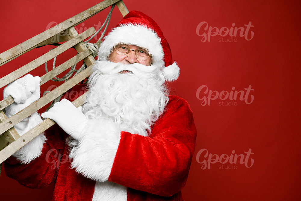 Caucasian Santa Claus with sled on red background  