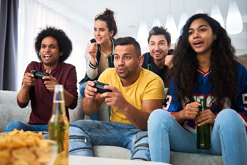 Group of friends spending time at home playing on the console
