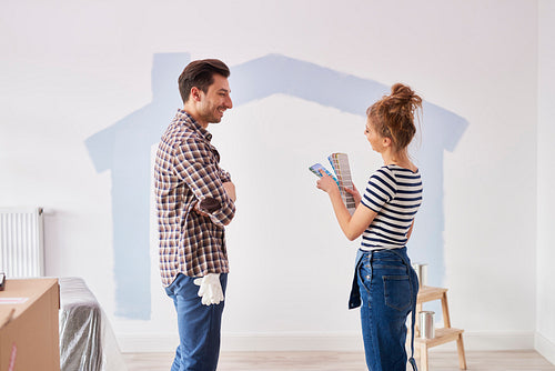 Couple painting the interior wall in their new apartment