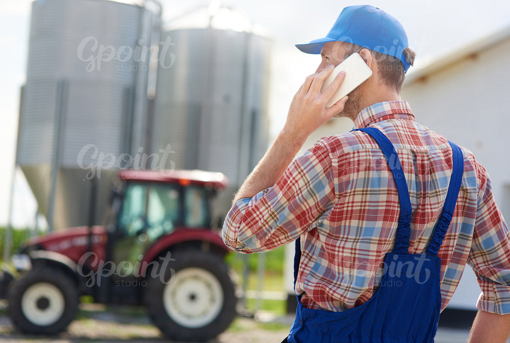 Rear view of farmer talking on the phone