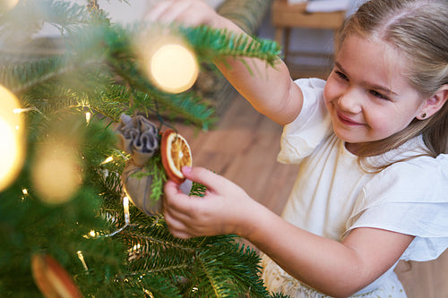 Cute little girl decorating Christmas tree
