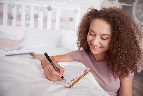 Beautiful teenage girl writing diary