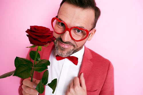 Man in red suit holding a rose