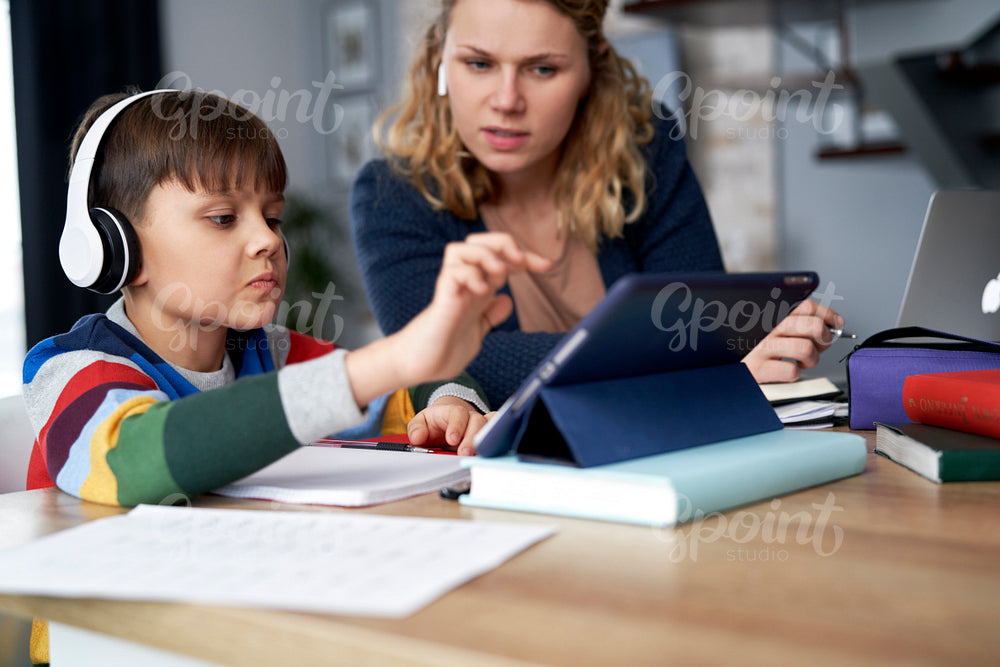 Mother assists her son while studying remotely
