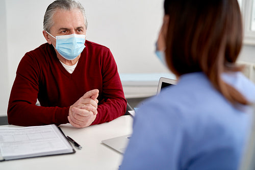 Senior patient in protective face mask in doctor's office