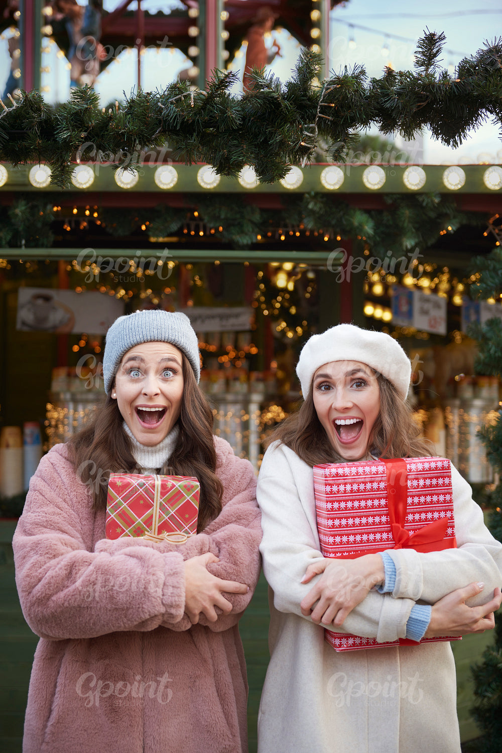 Surprised women with Christmas gifts on Christmas market