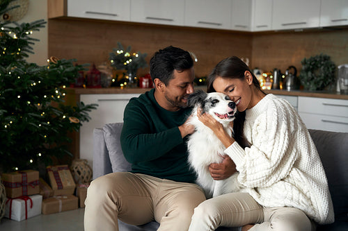 Multi ethnicity couple bonding with dog at Christmas time