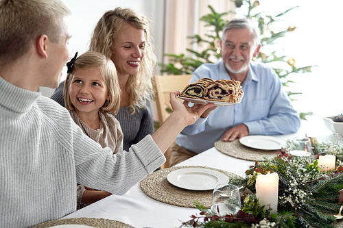 Caucasian family sharing poppy seed cake during the Christmas Eve