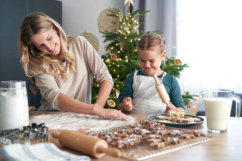 Caucasian woman with daughter making cookies and having fun in Christmas time in the kitchen