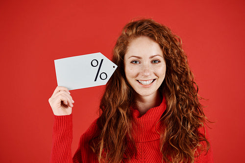Smiling woman holding blank price tag