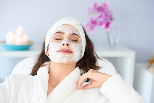 Relaxed woman is getting a face mask in spa