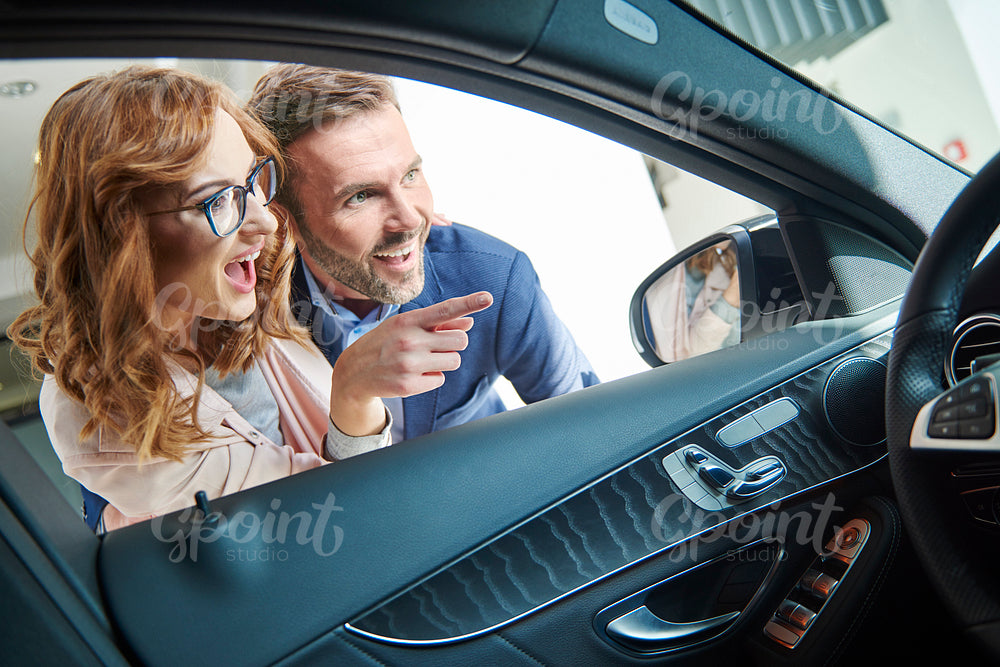 Couple admiring car in the showroom